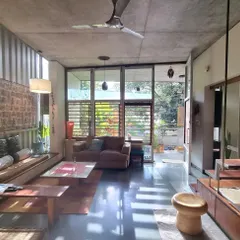 This is my sanctuary. The living space is designed to be open and connected to the small garden outside, with large windows and louvered panels that allow for natural light and cross-ventilation, essential for our tropical climate.