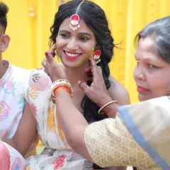 A candid moment from a Haldi ceremony in Rishikesh. The bride's makeup is minimal and radiant, designed to give her a natural glow that shines through the turmeric.