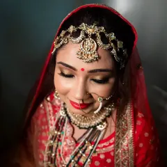 A beautiful high-angle shot of the bride in her red wedding lehenga, her eyes closed in a moment of serene contemplation.
