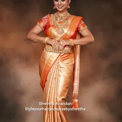 A classic bridal pose showcasing the full effect of a perfectly draped Kanjivaram saree. The pleats are set to fall gracefully, and the side sculpting ensures a flattering fit.