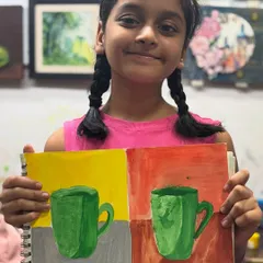 Another proud artist from our kids' batch with her colorful mug paintings. These exercises teach children about complementary colors and basic object drawing in a fun, creative way.