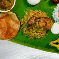 A close-up of our wood-fired mutton biryani served on a banana leaf. You can see the tender pieces of mutton mixed with perfectly cooked rice, a crowd favorite at every event.