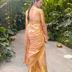 A stunning full-length view of our client Madhuri in a custom gold Kanjeevaram saree, complete with a bespoke backless blouse and a matching embroidered belt.