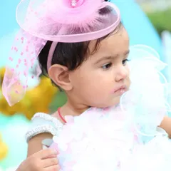 A close-up portrait of the birthday girl in her beautiful party dress and fascinator. I focus on capturing these details, from the outfit to the little smudge of cake on her lip.
