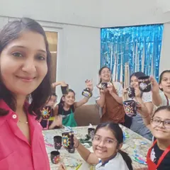 A group of smiling girls proudly display the dot mandala mugs they painted at Amaira's 11th birthday party. This photo captures the fun and focus of a craft-based art party, where everyone gets to take home a personalized souvenir.
