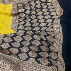 A classic black and yellow combination in a pure Banarasi Kadi georgette saree. The intricate gold weaving on the black pallu is absolutely stunning.