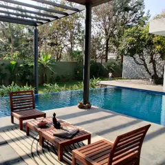 This sun-soaked island deck by the pool is the perfect spot for a cup of coffee. The design uses a simple pergola to define the space without closing it off from the beautiful garden views.