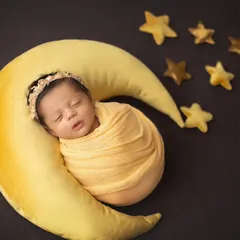 I love you to the moon and back. This celestial theme features a soft moon prop and twinkling stars, perfect for a dreamy and peaceful newborn portrait.