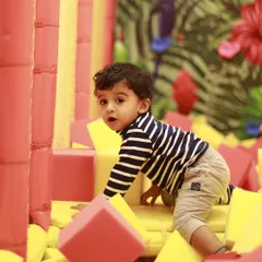 A curious toddler explores the soft blocks in our foam pit. This area is perfect for crawlers and early walkers to build confidence.