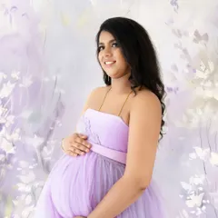An artistic portrait with a painted floral background that perfectly complements the lavender gown of the mom-to-be.