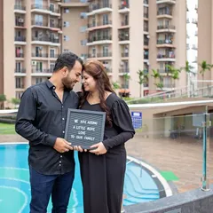 "We are adding a little more love to our family." This couple portrait by the pool with a letterboard is a sweet and modern way to announce their pregnancy.