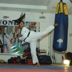A student practices a powerful side kick on a heavy bag in our dojang. We focus on developing proper form and explosive power in every technique.