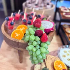 Refreshing fruit skewers served in individual cups, featuring watermelon, blueberries, and dragon fruit. These are a light and healthy option that adds a pop of color to any grazing table.