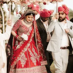 The bride's grand entrance under a beautiful floral canopy. Her makeup is designed to make a statement, ensuring she looks like a queen as she walks towards her new beginning.
