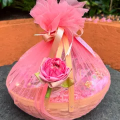 A close-up of the elegantly wrapped return gift basket, featuring pink tulle and a delicate lotus flower accent. The presentation is as important as the gift itself.