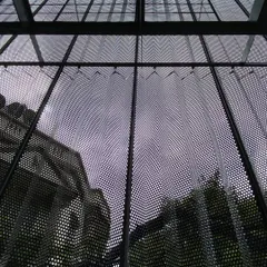 Looking up through the building's new skin, the sky is filtered and the reflection of the historic structure next door is captured. This detail shows how our interventions aim to connect the building to its context in new and unexpected ways.
