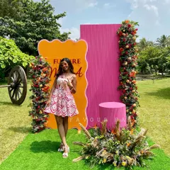 The gorgeous bride-to-be posing in front of the vibrant, modern backdrop we created for her bridal shower. The mix of orange and pink with lush florals was perfect for this outdoor celebration.