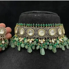 A stunning green and white kundan choker set with a modern design. The large circular kundan stones are surrounded by fine American diamond work and finished with green bead tassels, perfect for a sangeet or reception party.