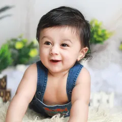 A heart-melting smile from a six-month-old. The simple denim overalls and soft rug keep all the focus on his adorable face.
