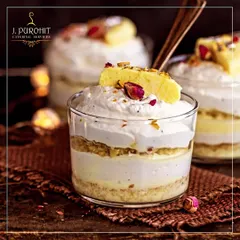 A close-up of my fusion dessert, Rasmalai Tres Leches. This dessert combines the flavors of Indian rasmalai with the texture of a creamy Latin American tres leches cake, garnished with rose petals.