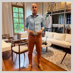 Here I am in my studio, showing how to elevate office dressing with a perfect play of colors. I've paired a light blue shirt with rust-colored trousers for a look that is both professional and stylish.