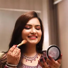 A happy moment during the getting-ready process. This bride is checking her makeup, looking radiant and confident for her Roka ceremony.