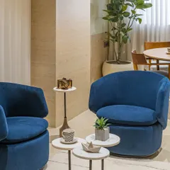A wider view of the Director's lounge area, showing how the comfortable seating is balanced with natural elements like the large planter, creating a refreshing and creative atmosphere.