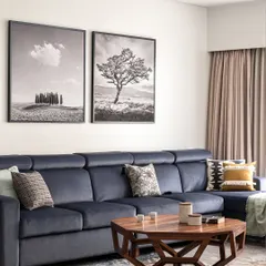 This living room is a cozy cocoon, designed for ultimate relaxation. The deep, inviting sofa is perfect for sinking into, while the geometric wooden coffee table adds a touch of modern character. The black and white art provides a classic, sophisticated backdrop.