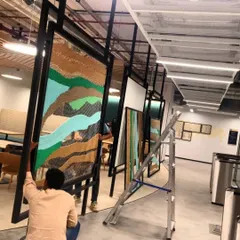 My team carefully installing one of the large, metal-framed tapestry panels. Executing large-scale corporate art requires precision, teamwork, and a deep understanding of the space.