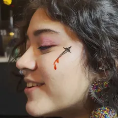 A creative and edgy look for a Swiftie. This temporary face tattoo of a dagger with a blood drip was a popular request at the event.