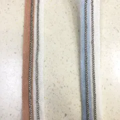 A pair of simple yet elegant trims featuring a delicate metal ball chain stitched onto a fabric base. Available in different colors, this is a subtle way to add a metallic accent to garments.