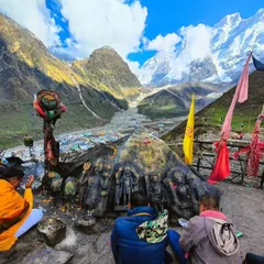 Devotees praying with a panoramic view of the Kedarnath valley and temple behind them. This photo captures the essence of pilgrimage: faith set against the immense scale of nature.