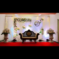 For a touch of classic elegance, we design beautiful reception stages like this one. The combination of a lush floral arch, hanging bouquets, and soft lighting creates a romantic and sophisticated backdrop for your celebration.