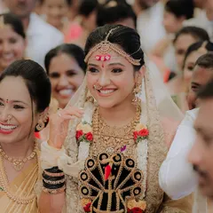 A candid shot of a happy bride during her wedding ceremony. Her traditional saree is draped perfectly to allow for comfortable movement while maintaining an elegant silhouette.