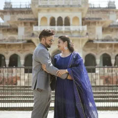 A sophisticated couple portrait in front of the Albert Hall Museum. The classic architecture and the couple's elegant blue outfits create a picture of timeless grace.