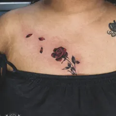 A classic red rose tattoo on the chest. The deep red color and delicate shading on the petals give this piece a timeless and romantic feel.