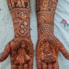 A classic depiction of a royal bride and groom, each on one palm, framed by intricate arches. The forearms continue the story with a wedding procession featuring decorated elephants.