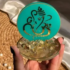 Here is a close-up of a mini Ganesha stand in a beautiful teal color. The base is filled with gold flakes for a touch of sparkle, and the Ganesha motif is detailed in gold.