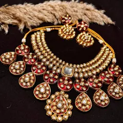 A magnificent Polki Kundan necklace set with red enamel work. This rental set includes the layered necklace, matching earrings, and maang tikka for a complete, opulent look.