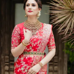 A closer look at the red Banarasi saree, highlighting the exquisite temple jewelry and the detailed embroidery on the blouse.