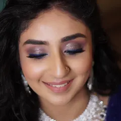 For a unique reception look, we added a pop of electric blue eyeliner over a shimmering, smokey base. It’s a modern and playful way to incorporate color into your bridal makeup.