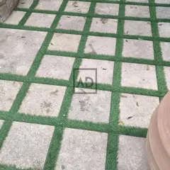 A popular and practical design for walkways and patios. I install strips of artificial grass between stone or concrete pavers to soften the look, add a touch of green, and eliminate the need for weeding.