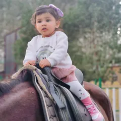 A close-up of a young child securely seated on the saddle. Our team is always on hand to assist during photoshoots with children to ensure their comfort and safety.