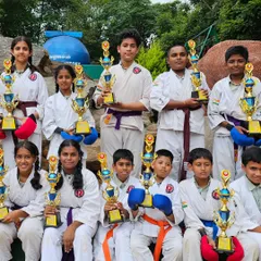Our team of young karateka posing with their trophies. Each student, from white belt to black belt, is a valued member of our competitive team.