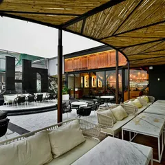 The restaurant's outdoor patio was designed as a modern oasis. We combined comfortable lounge seating with durable, stylish materials and a bamboo canopy to create a versatile space for alfresco dining and events, seamlessly extending the restaurant's sophisticated atmosphere.