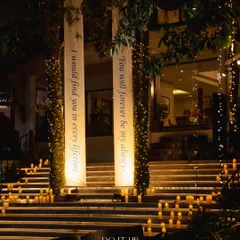 A romantic entrance for a Sangeet in Rishikesh. The steps leading to the venue are lined with hundreds of candles, and custom banners with love quotes create a deeply personal and dramatic welcome.