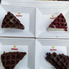 An assortment of our irresistible waffles, including classic, chocolate, and red velvet flavors. Our branded plates add a professional touch to the dessert experience.