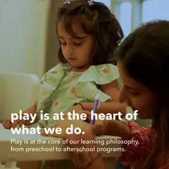 Play is at the very core of our learning philosophy. This image captures a moment of gentle guidance, where a teacher supports a child's exploration, which is central to how we approach early education.