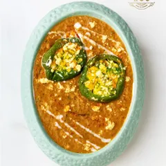 A gourmet take on a homely classic. These bell peppers are stuffed with a savoury mixture of paneer and spices, then simmered in a rich, flavourful gravy. The presentation with a swirl of cream makes it worthy of a fine dining table.