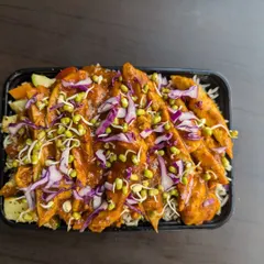 This meal box features tender chicken strips in a savory sauce over a bed of rice and vegetables, topped with fresh sprouts for extra texture and nutrients. It's a popular choice for a post-workout refuel.
